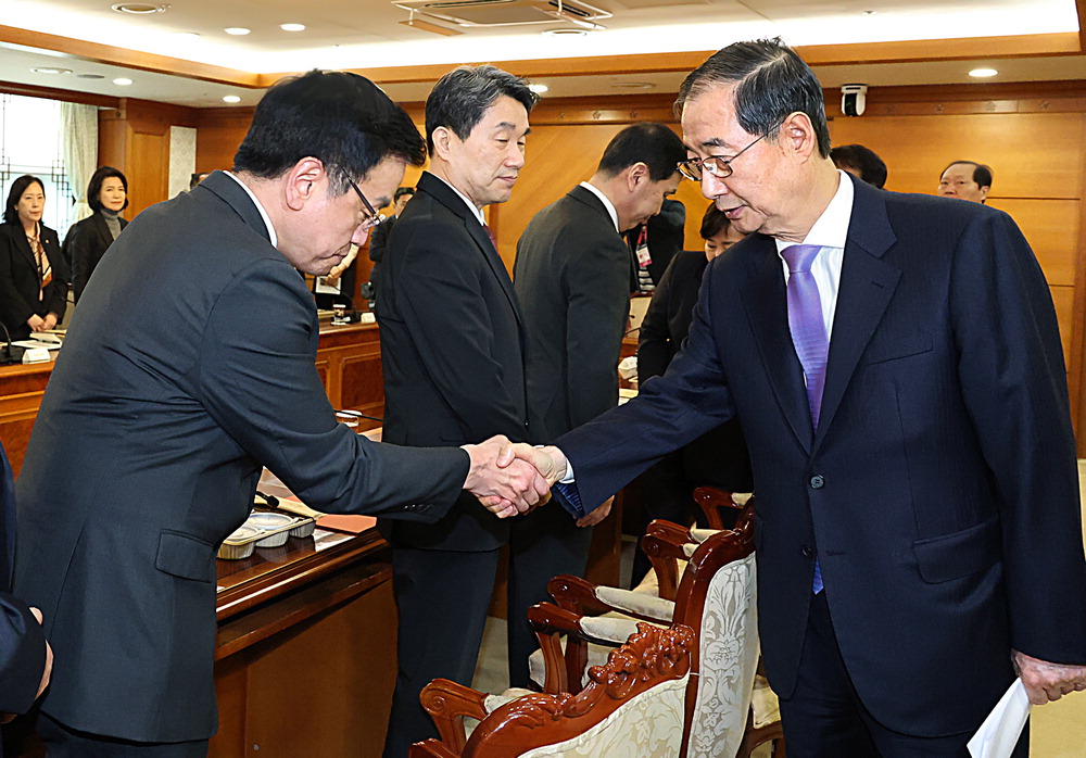 대통령 권한대행 '바통 터치' 헌법재판소에서 탄핵소추안을 기각해 직무에 복귀한 한덕수 대통령 권한대행 국무총리(오른쪽)가 24일 정부서울청사에서 국무위원 간담회를 진행하기에 앞서 87일간 '대행의 대행' 역할을 해온 최상목 경제부총리 겸 기획재정부 장관과 만나 악수하고 있다. 가운데는 이주호 사회부총리 겸 교육부 장관. 이승환 기자
