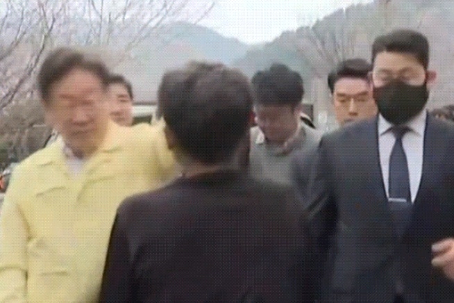 27日、慶尚北道英陽郡（キョンサンプクト·ヨンヤングン）の被災者避難所近くで、黒い服を着た男性が李在明（イ·ジェミョン）共に民主党代表に向かって服を振り回す姿。 [写真出典=MBN]